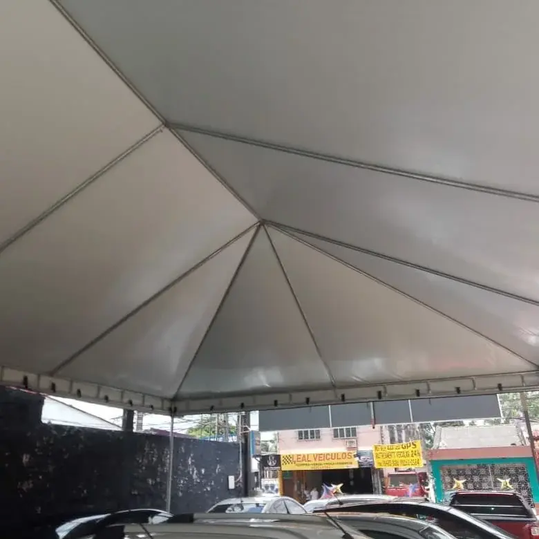 Vista de baixo da lona branca e das barras metálicas de uma cobertura