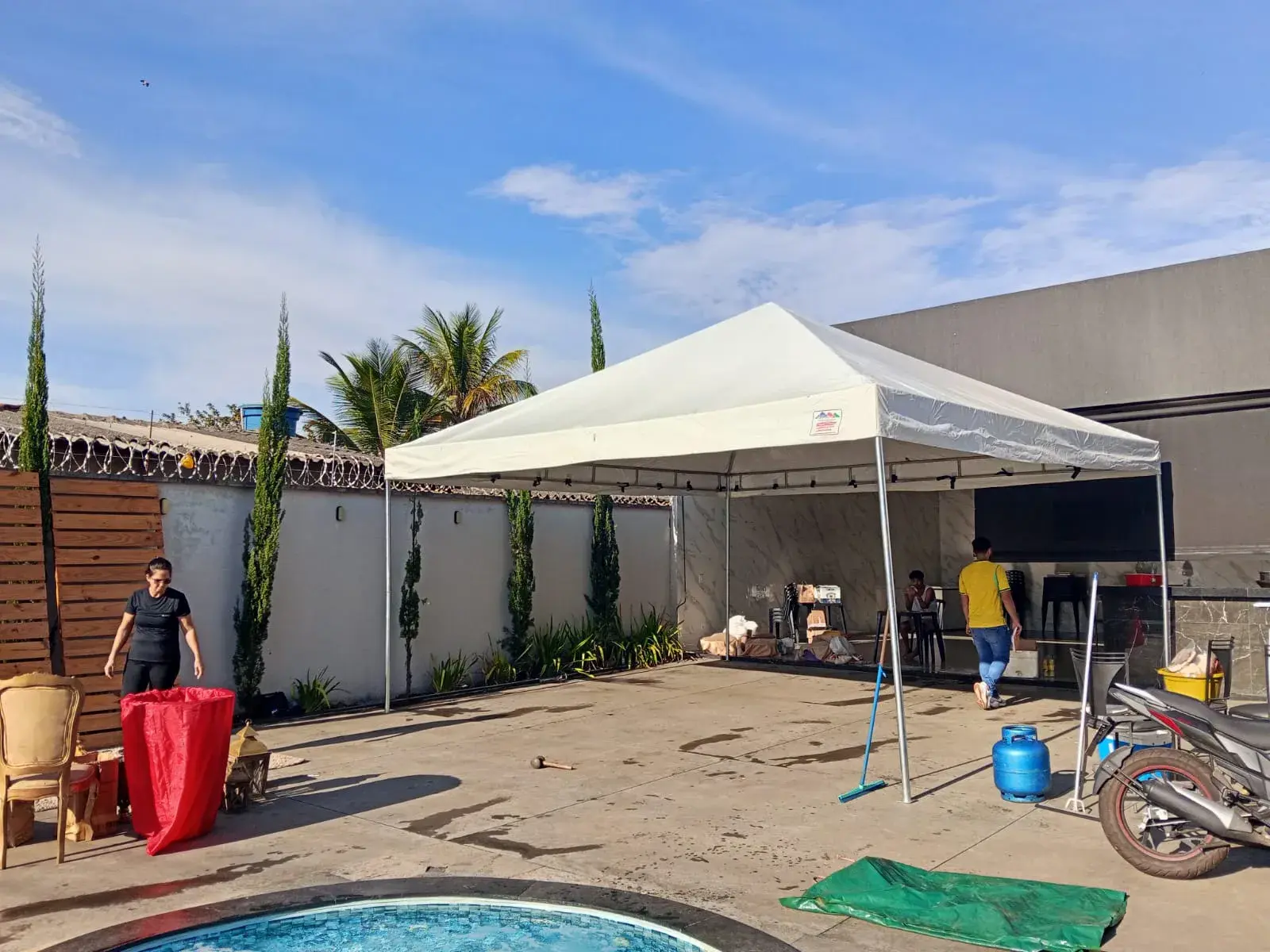Tenda branca montada em área de lazer ao lado de uma piscina